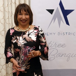 Cuca Costas smiles a for picture with her vase at the 2023 Retiree Banquet